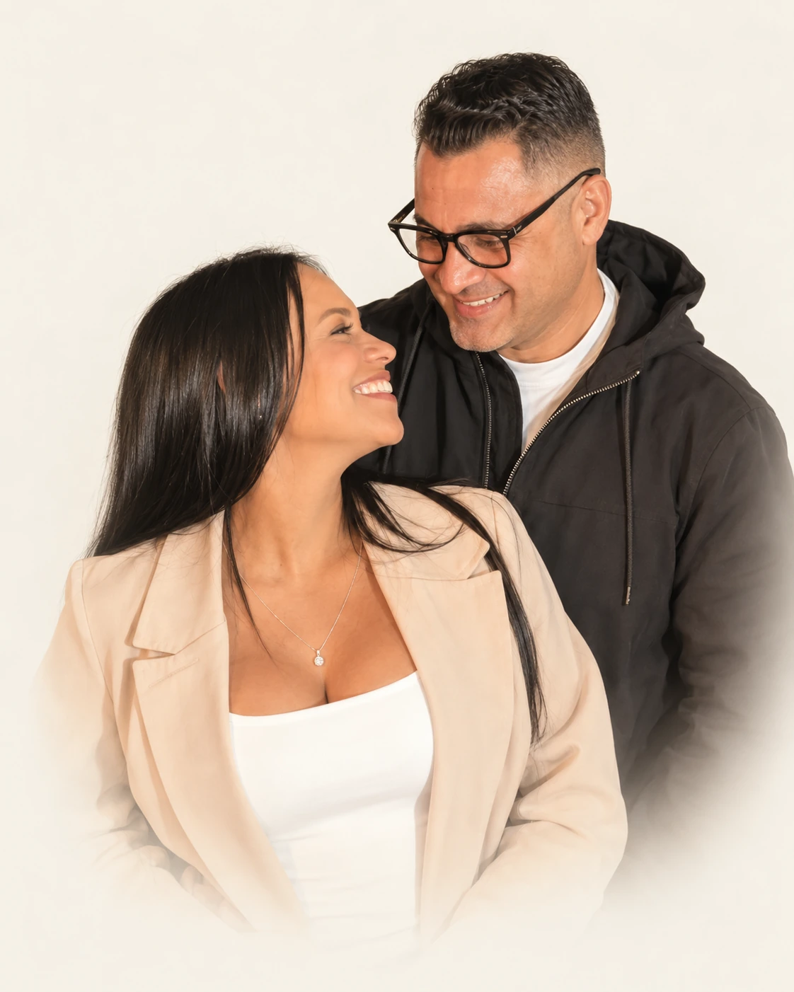 Retrato de Wilmer y Leydi mirándose y sonriendo sobre un fondo marfil suave.